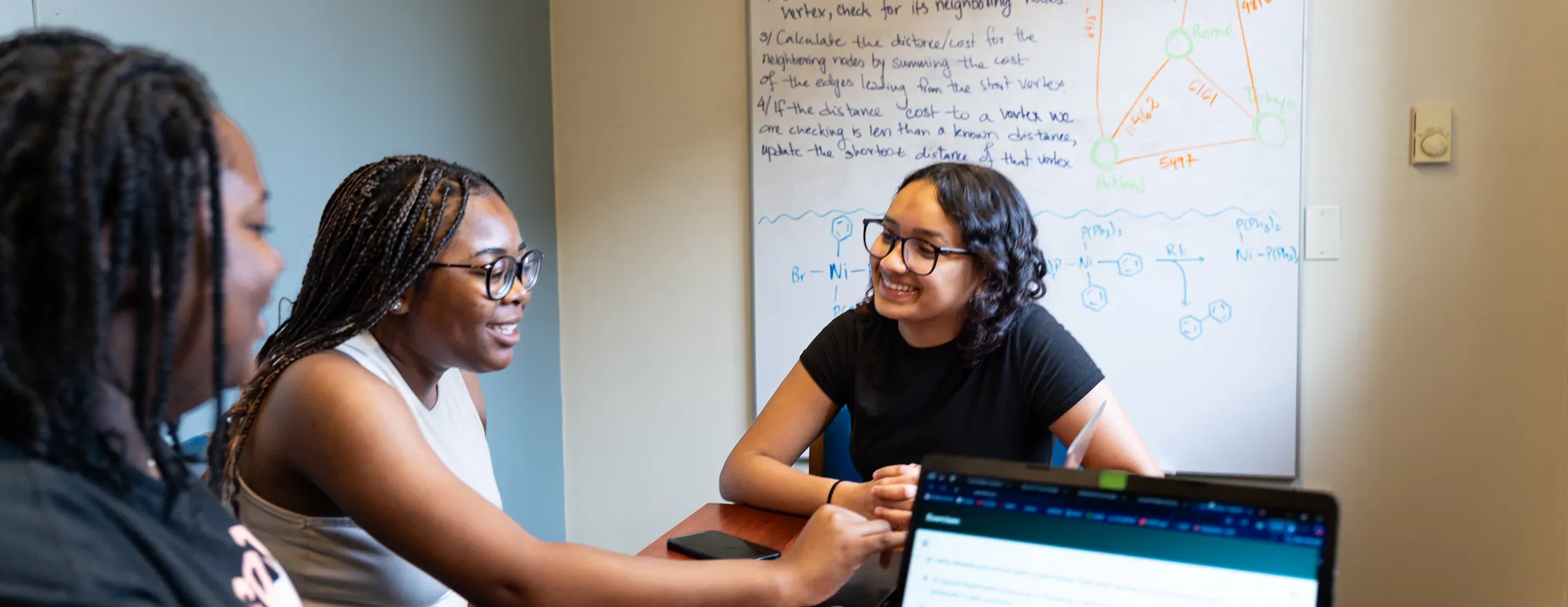 Three students work on computer science in the quantitative q center