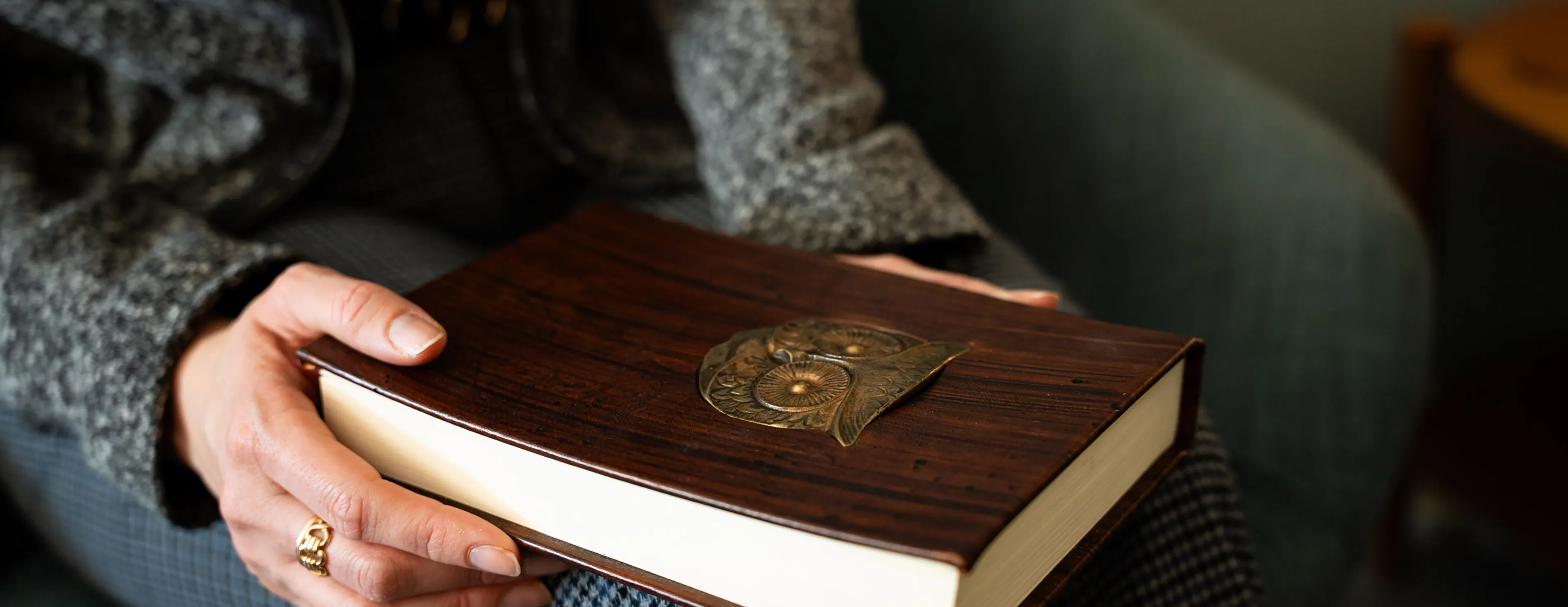 A philosophy student holds a book with an owl on it