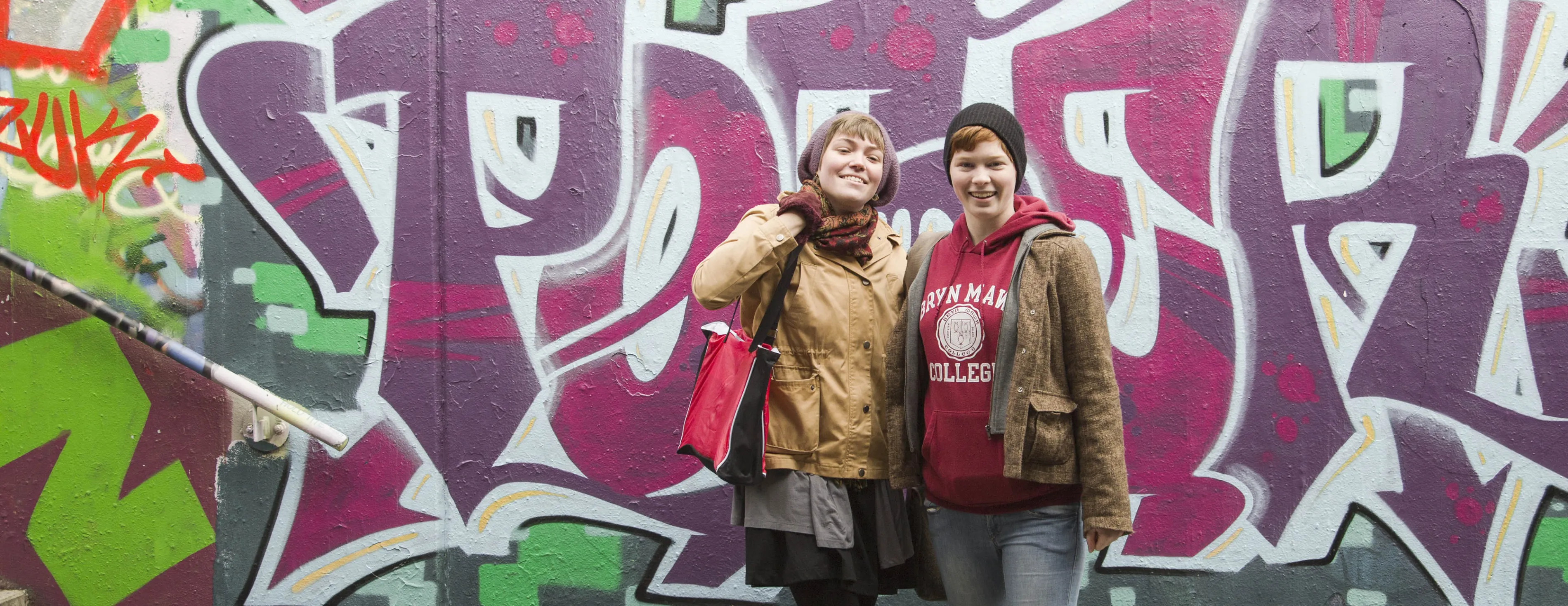 Two Bryn Mawr College German Studies students stand in front of street art in Germany