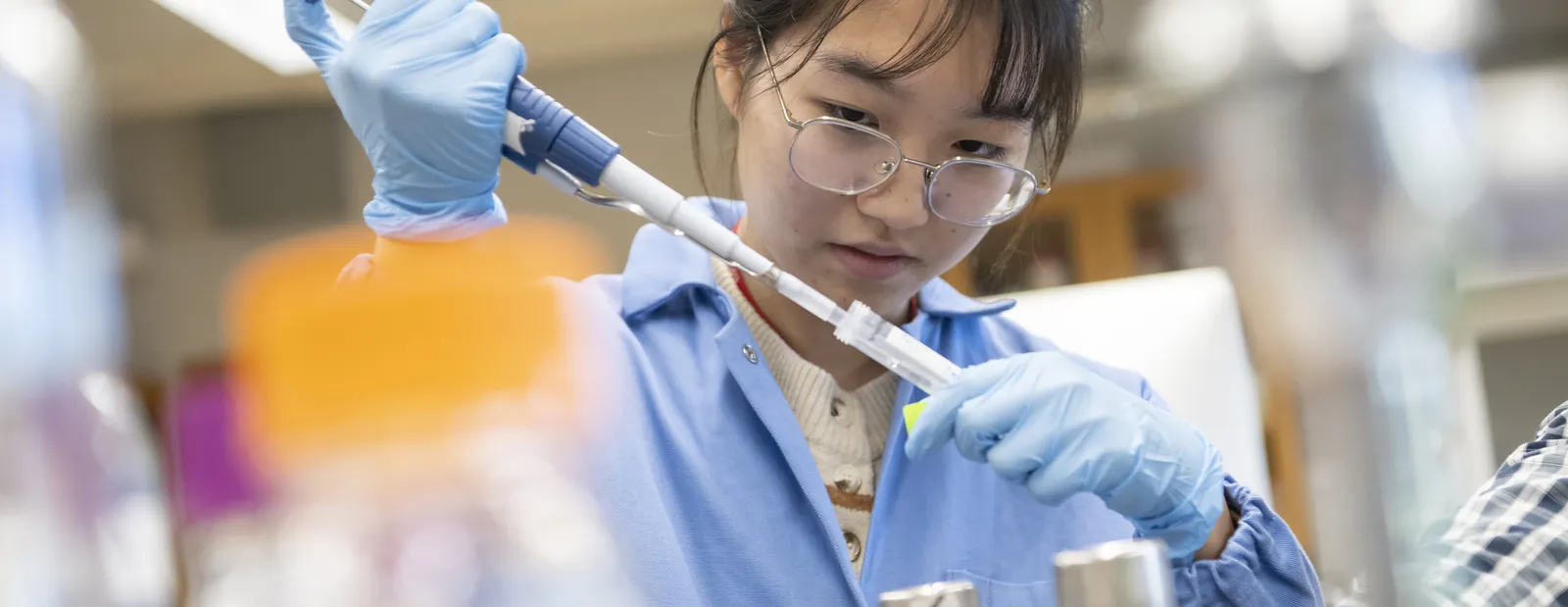 A student at Bryn Mawr college uses a pipette in a chemistry lab