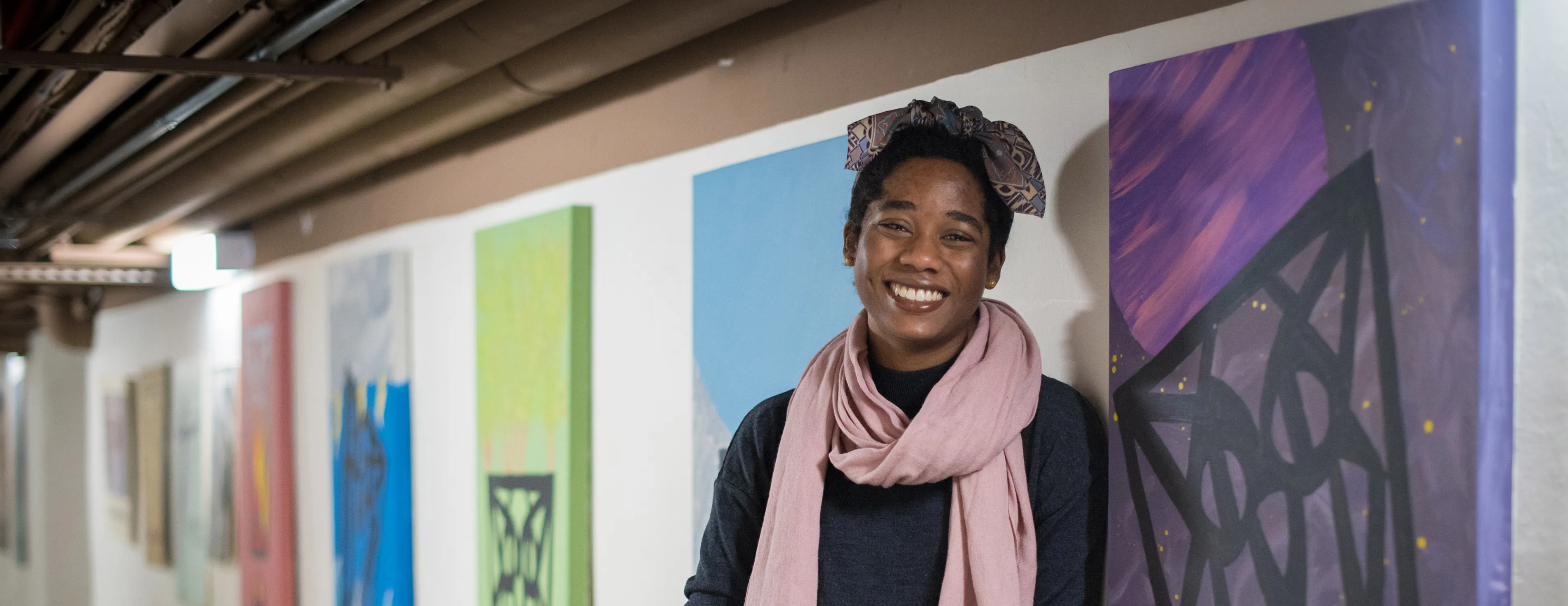 A fine arts student stands with her campus improvement project