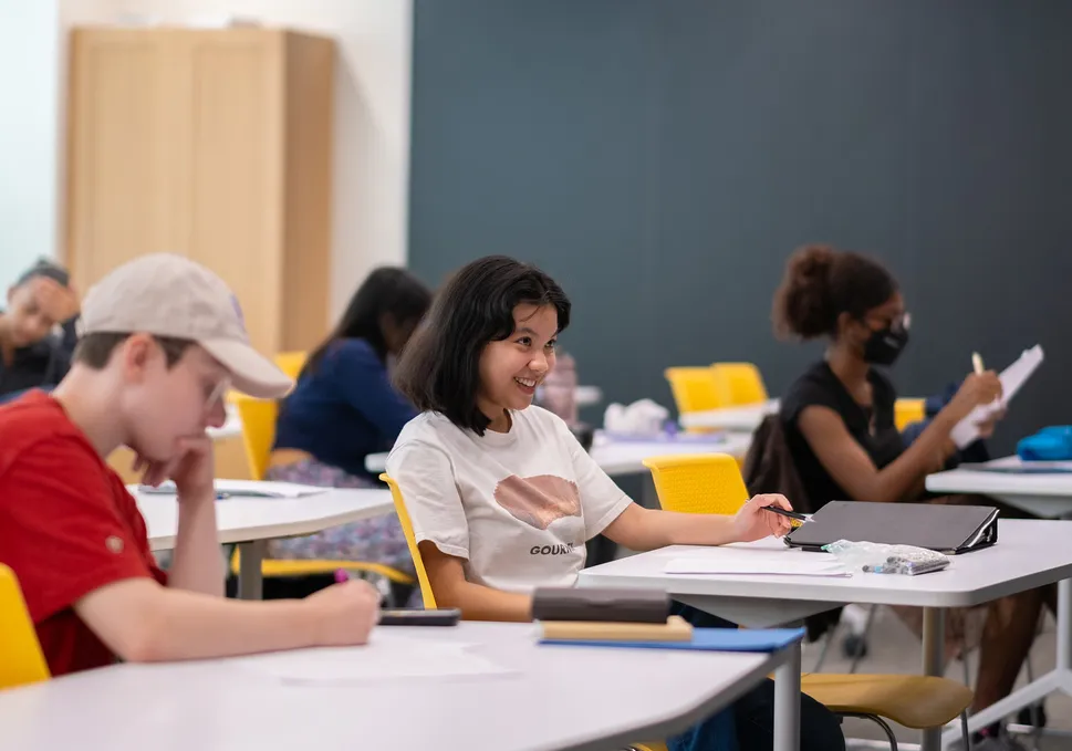 student smiling at desk