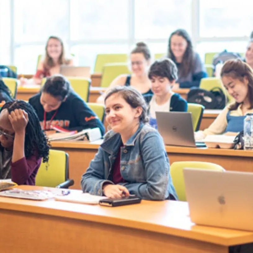 Students with laptops in a classroom learning