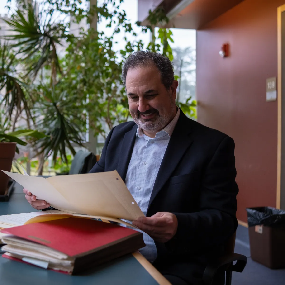 Marc Schulz smiling as he looks down at his files