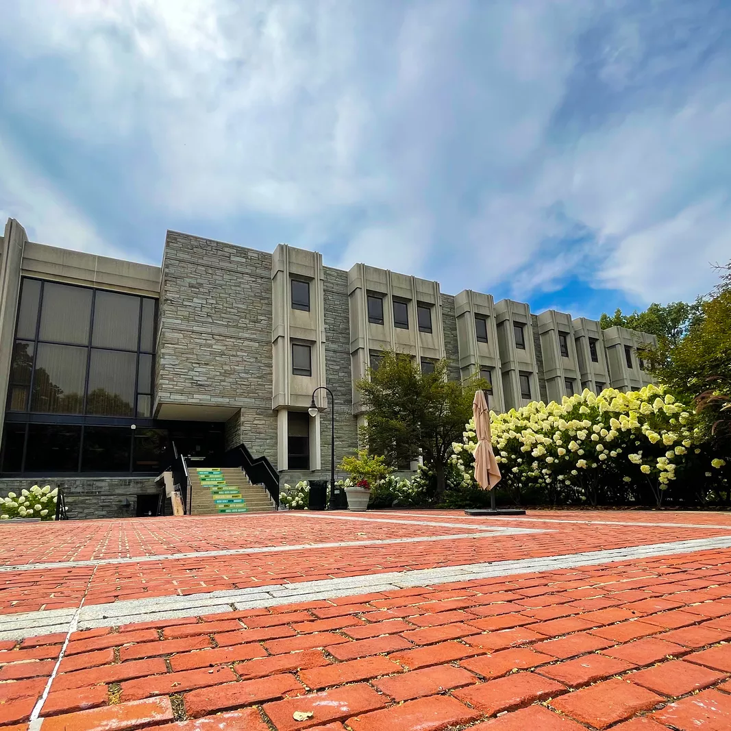 Brick walkway leading to three story stone building