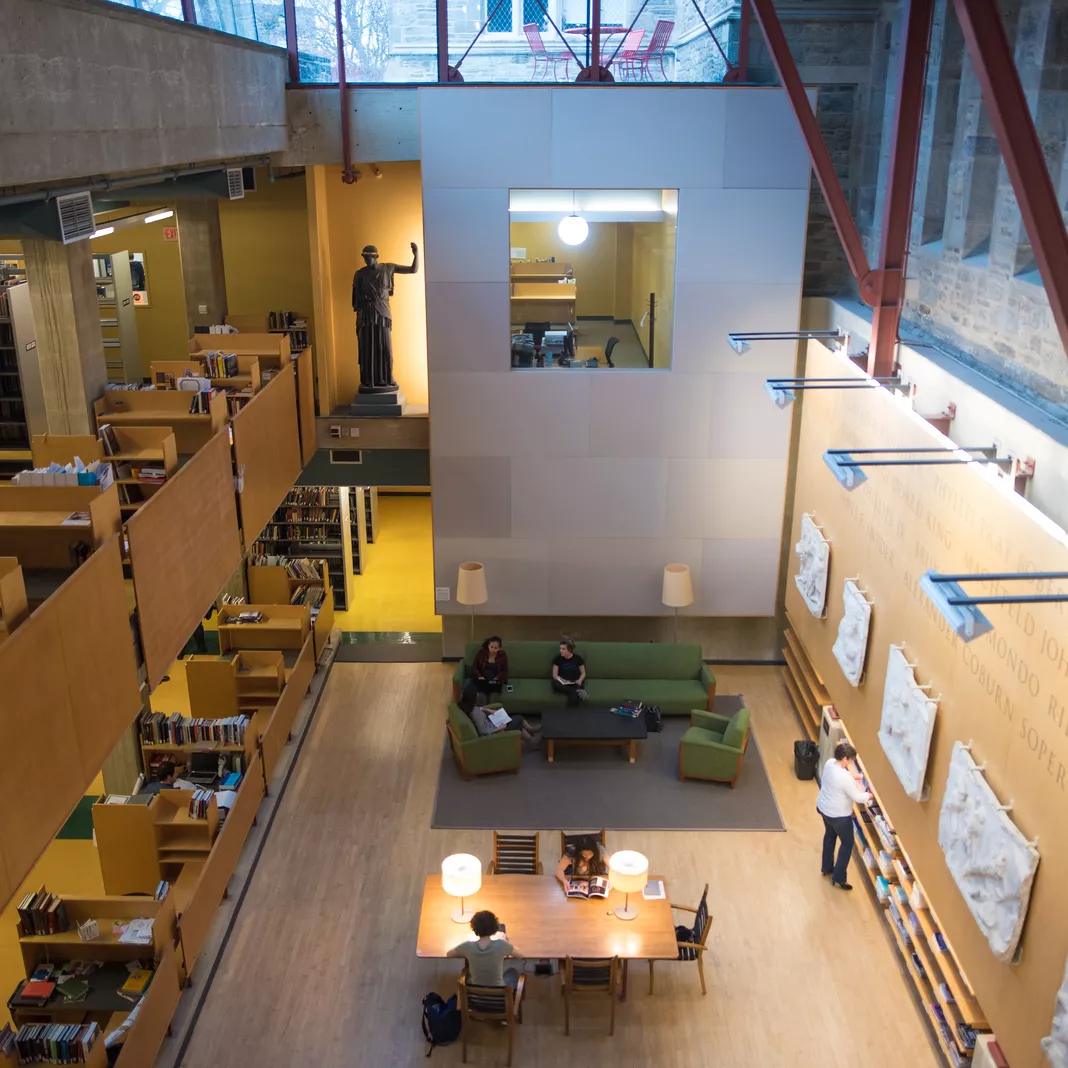 Students studying inside a wood and glass library