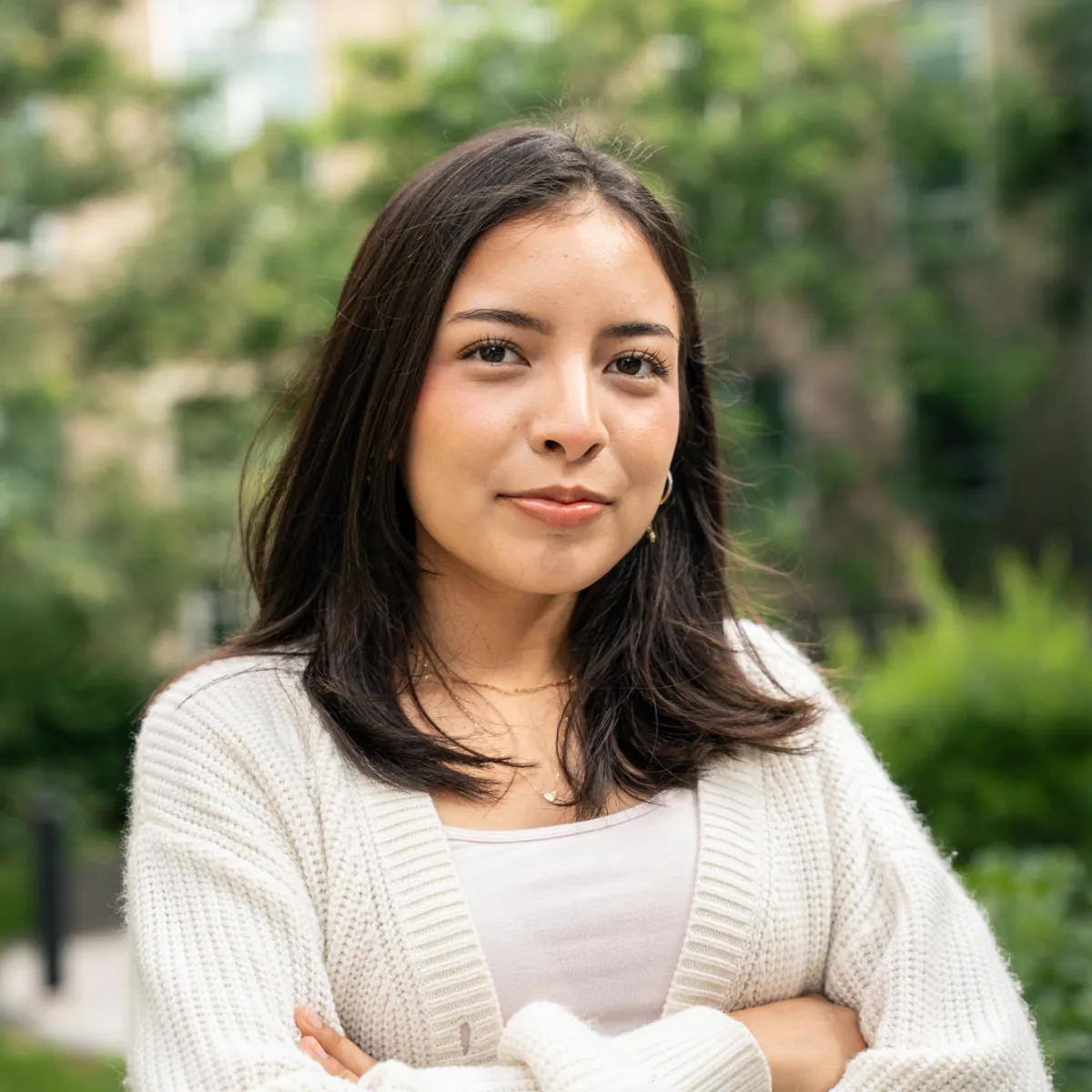 Dana Gahuancela Pesantez in white sweater posing for headshot