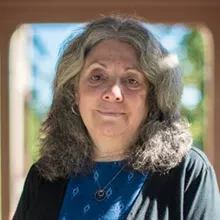 Woman with gray hair in a blue shirt
