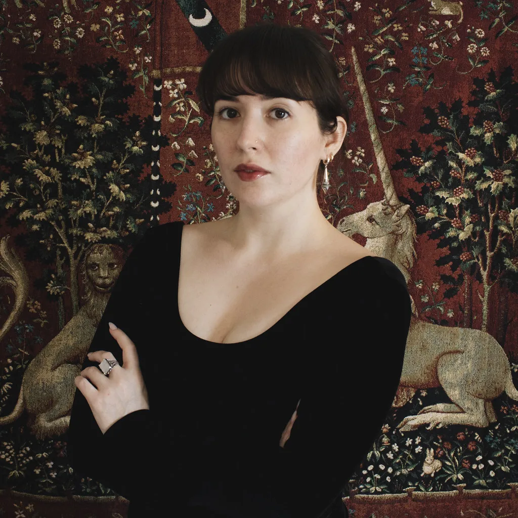 Image of Danielle Pigeon in front of a tapestry
