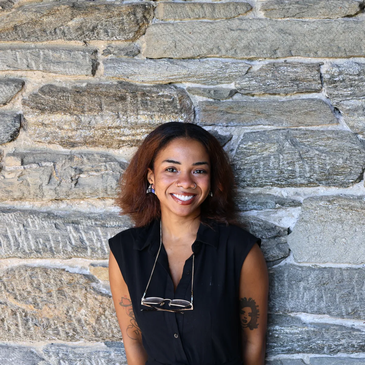 Venus Myrick poses in front of a stone wall