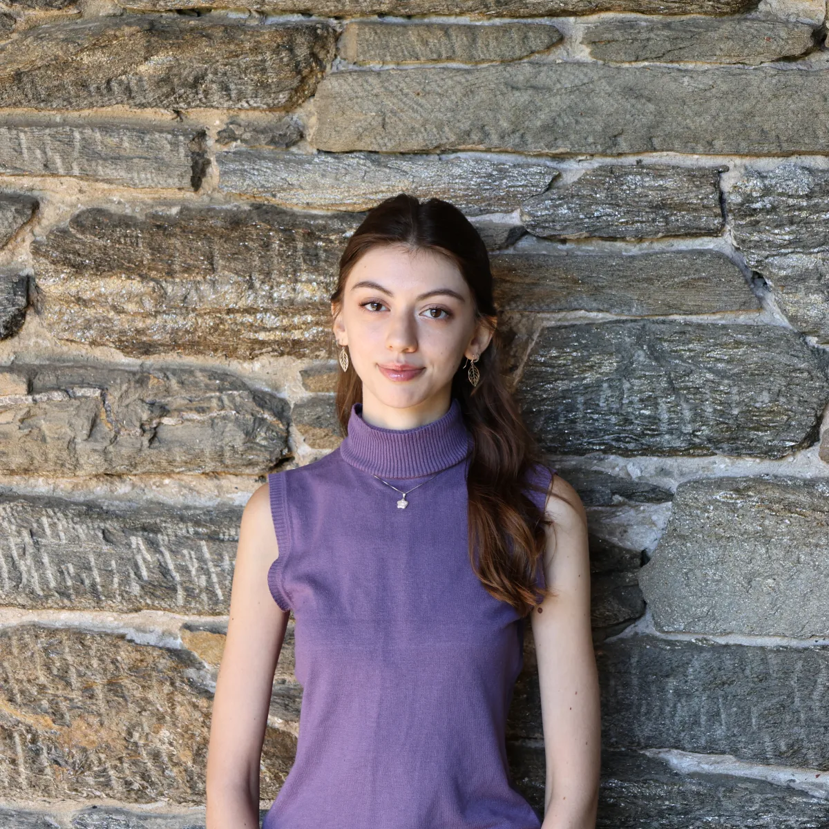 Aleksia Taci poses in front of a stone wall