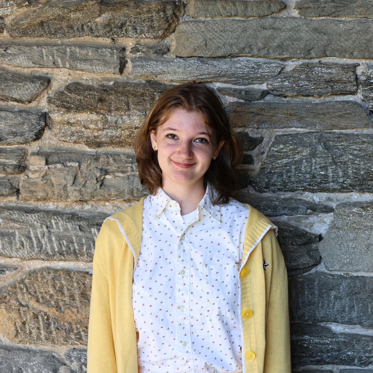Lucia Iurino poses in front of a stone wall