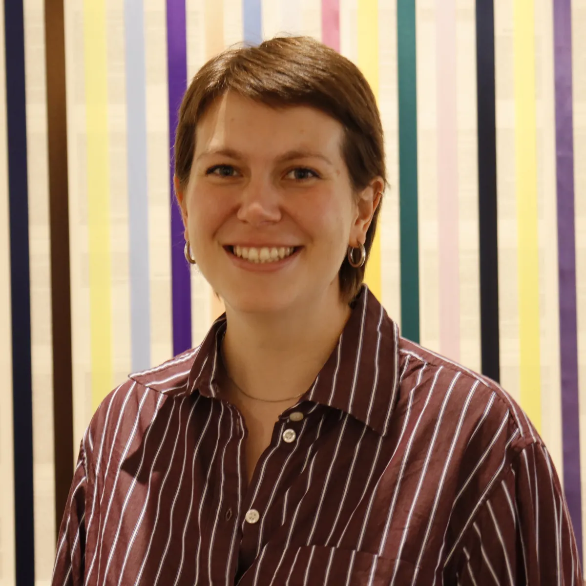Headshot of Hilde Nelson in front of a striped background