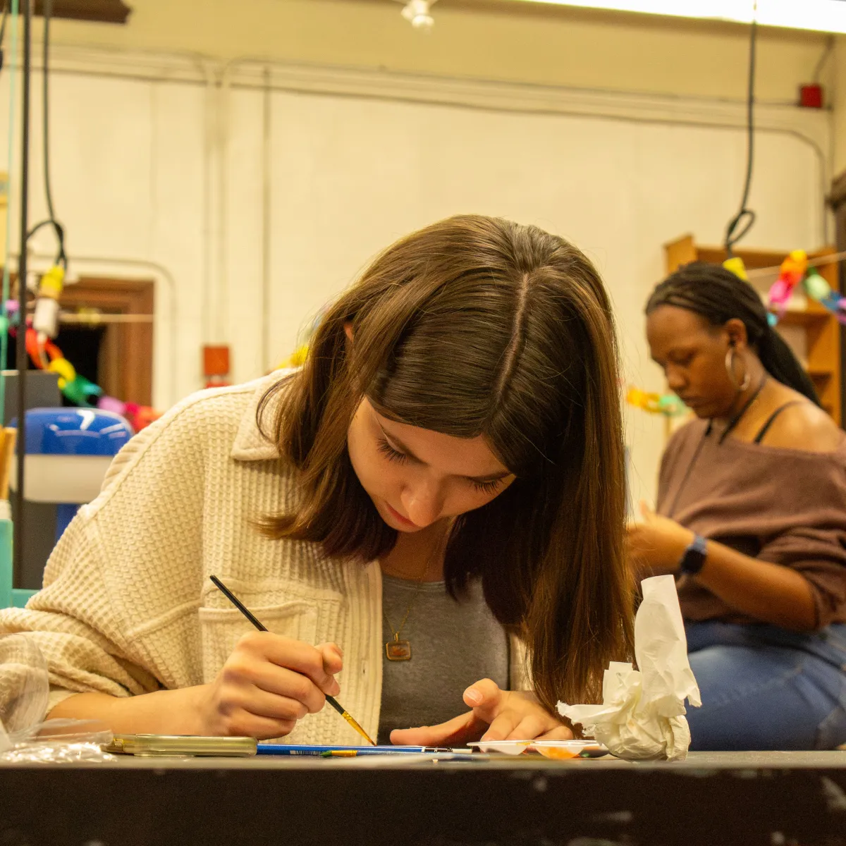 A student paints in art club