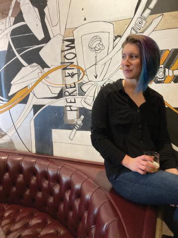 Allaina Propst sitting in front of a mural