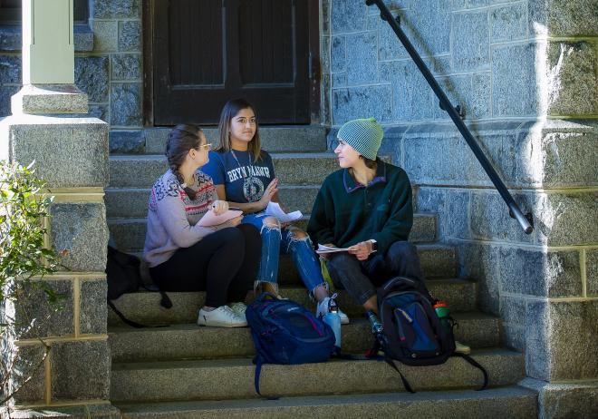 students sitting on steps in front of merion hall