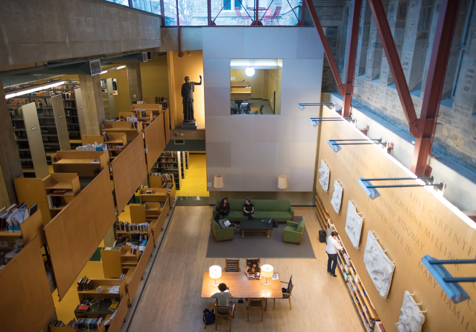 Students studying inside a wood and glass library