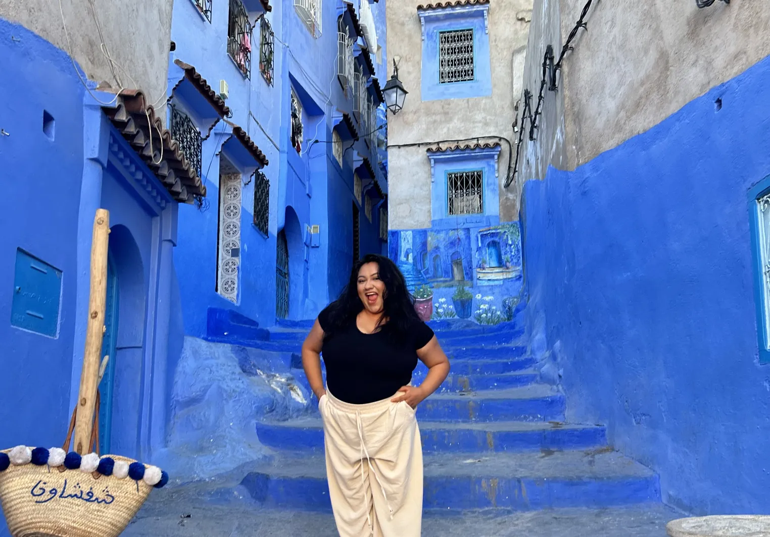 Jackie standing in at the bottom of a bright blue staircase