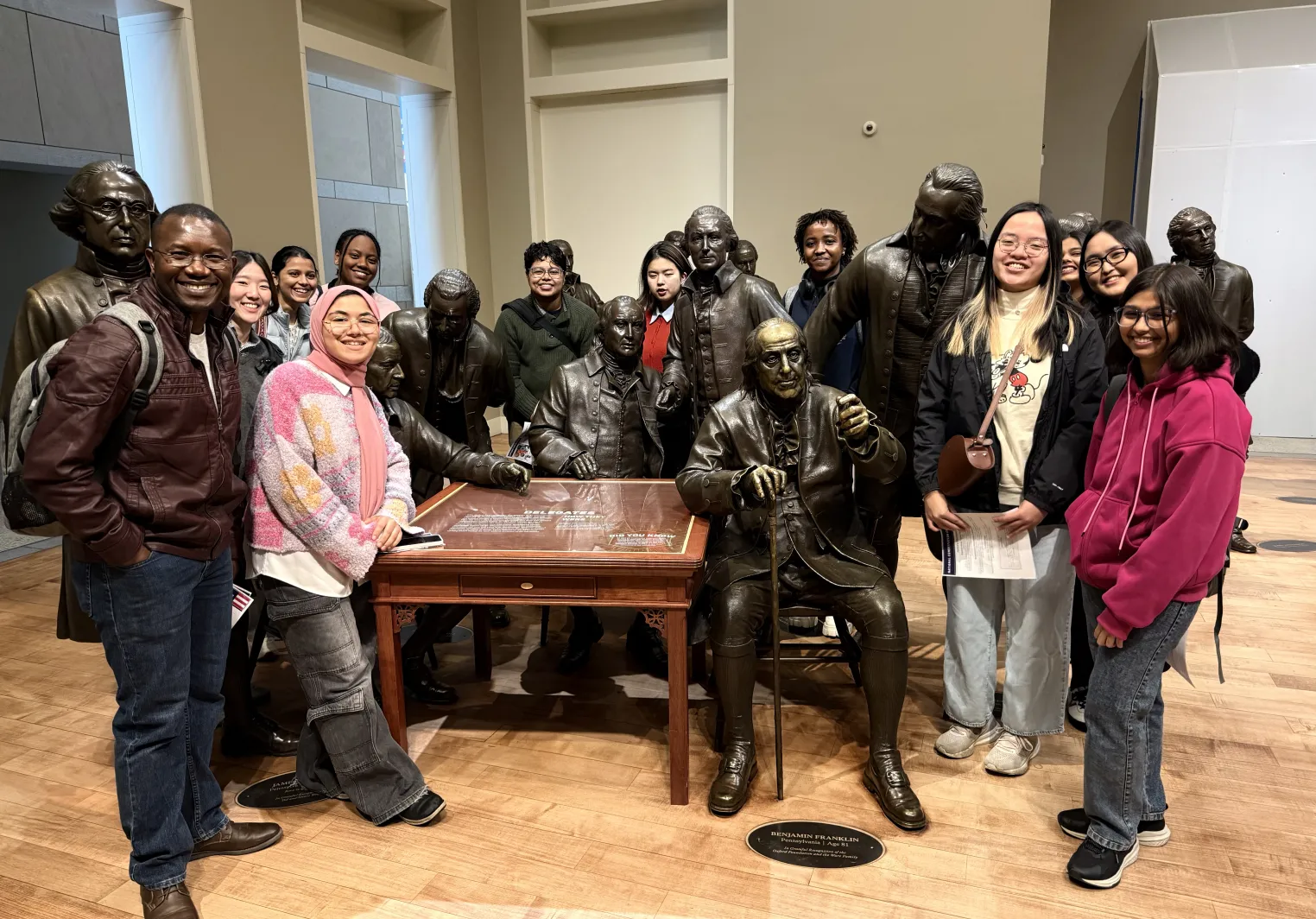 International Students posing in front of statues at the National Constitution Center