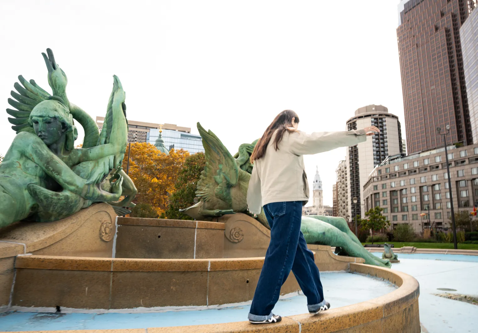 A student of Philosophy at Bryn Mawr College walks along a fountain in Philadelphia