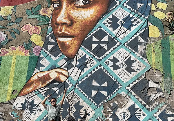 A Bryn Mawr College student on a 360 Trip to Cape Verde in West Africa with a mural