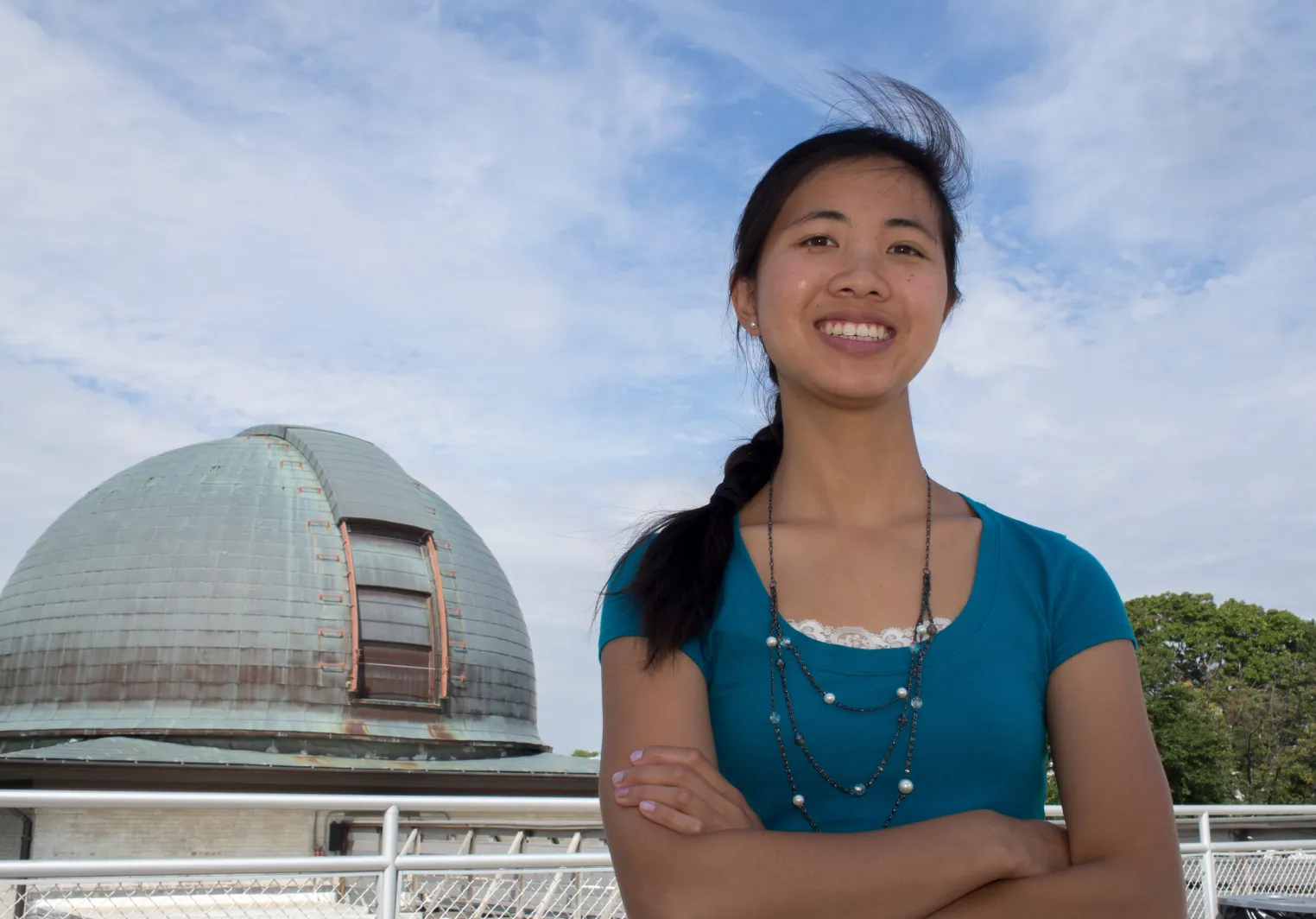 A Bryn Mawr College astrophysics student stands in front of an observatory