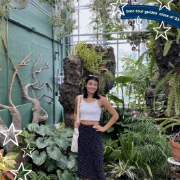 Maya smiling in a greenhouse