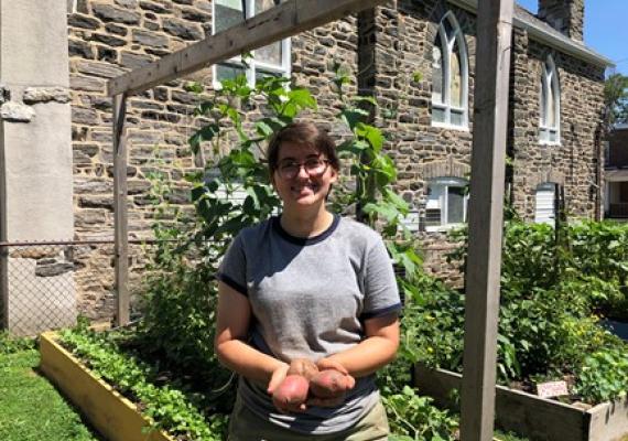Rachel Gass at the Ardmore Victory Garden holding small potatoes
