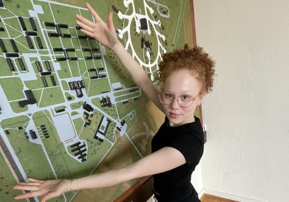 Clara Schilling in front of a map on the wall