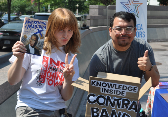 Two people holding signs. 