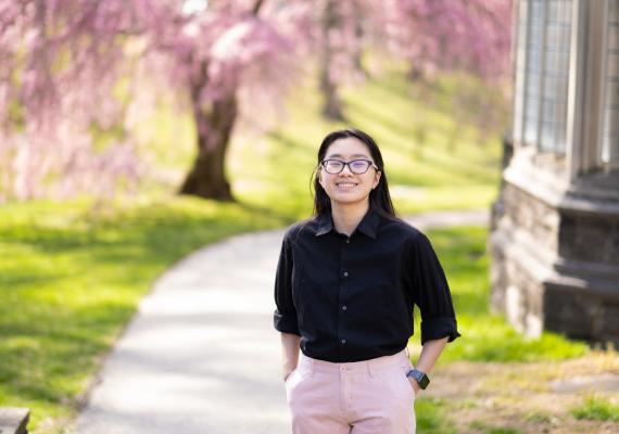 Glory Zhang in front of cherry blossom tree
