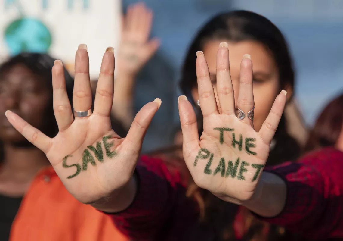 Protester with "Save the Planet" written on hands