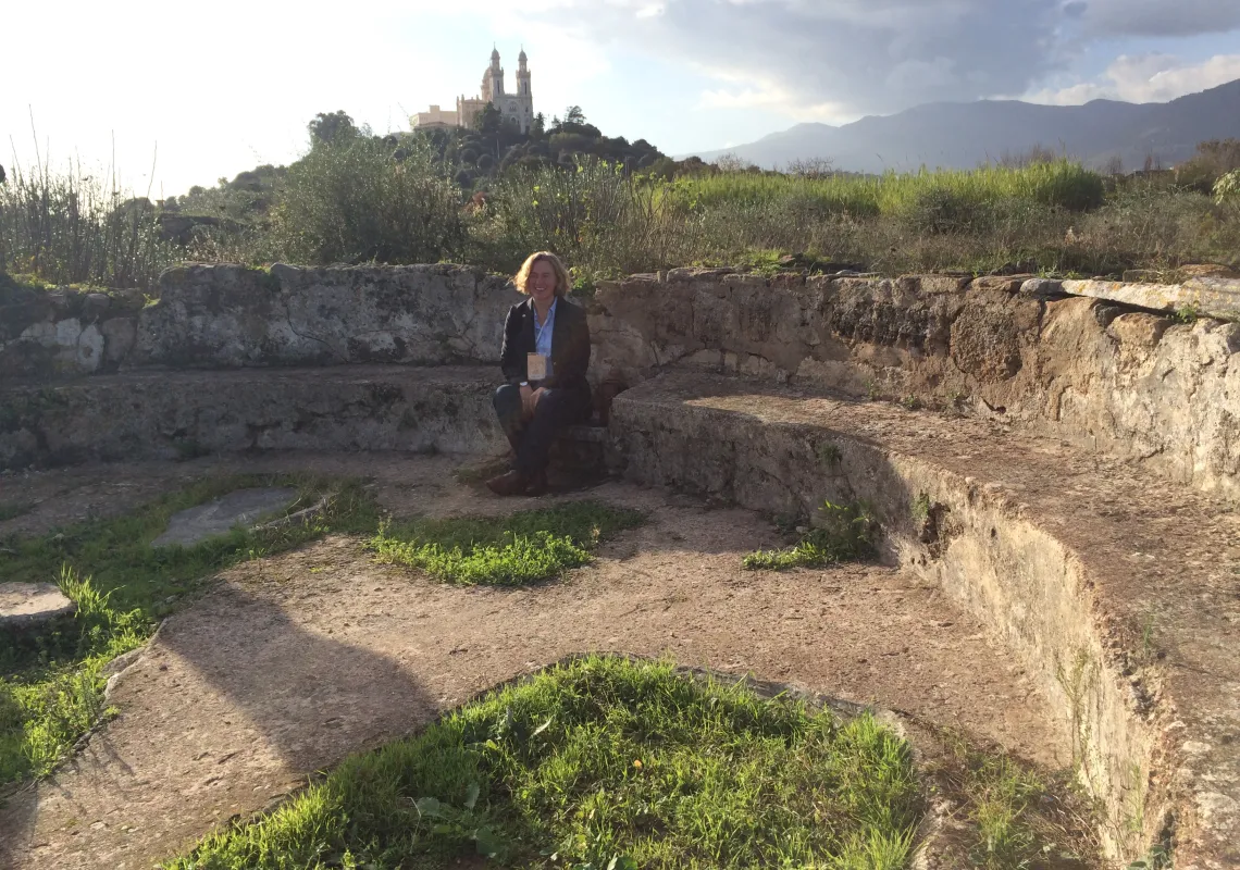Catherine Conybeare sitting in the ruins of Augustine's Church