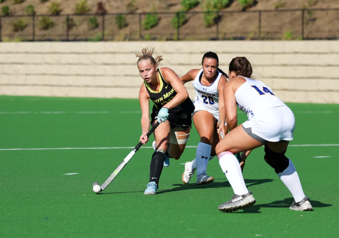 Three field hockey players on the field