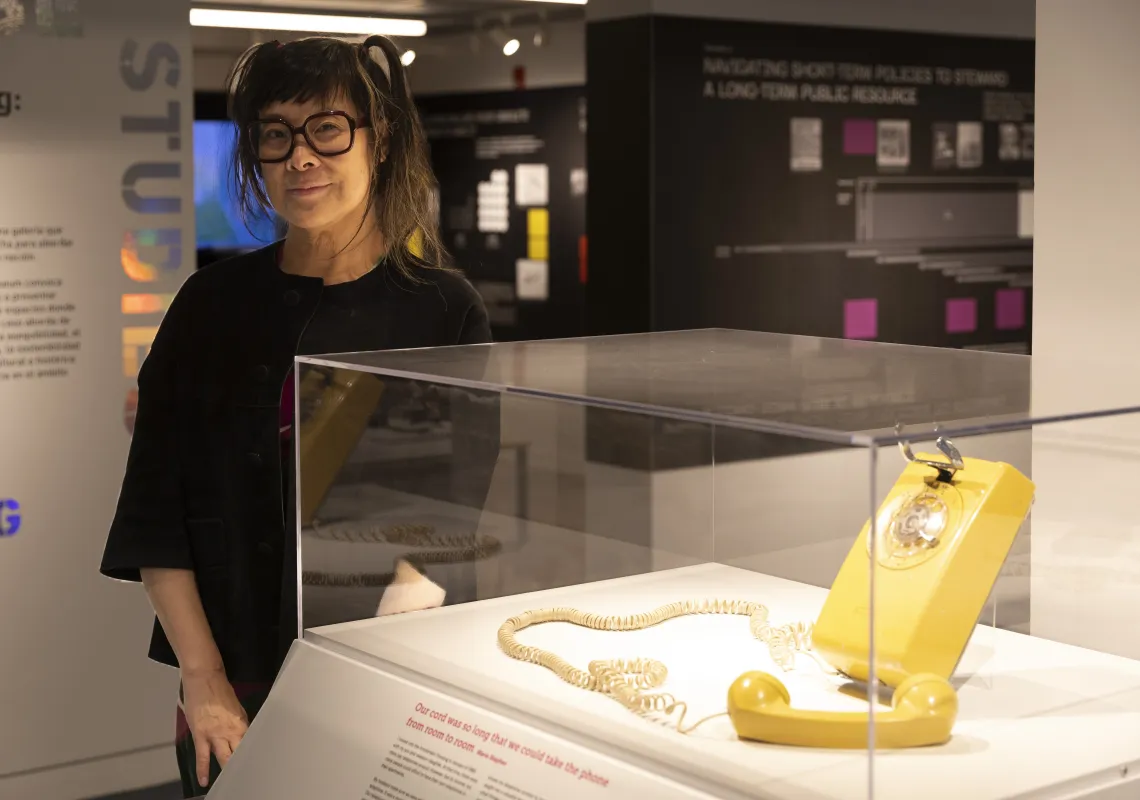 Lisa Yun Lee ’91 beside a rotary phone on display at the National Public Housing Museum