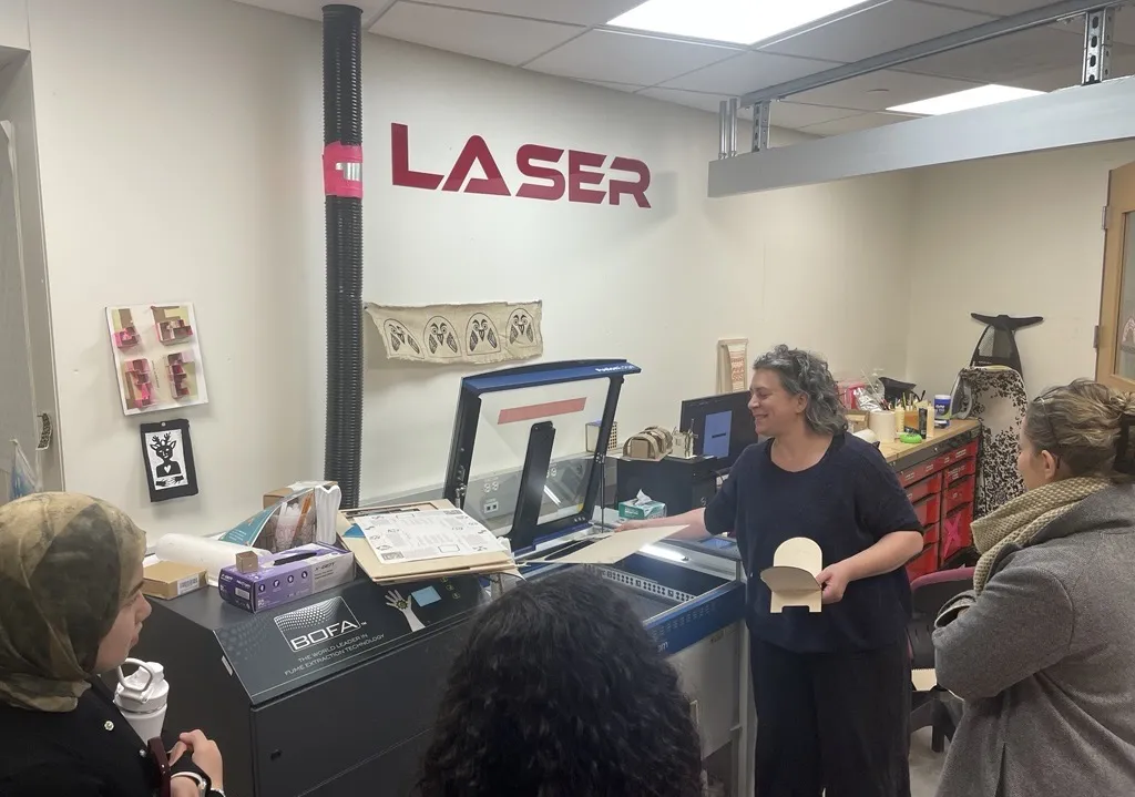 Bronwen Densmore instructs attendees to a workshop on making rehals about how to use the laser cutter