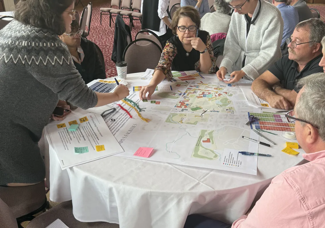 people working on a a map around a table