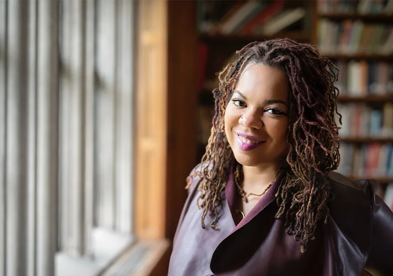 Dee Matthews portrait in front of bookshelves