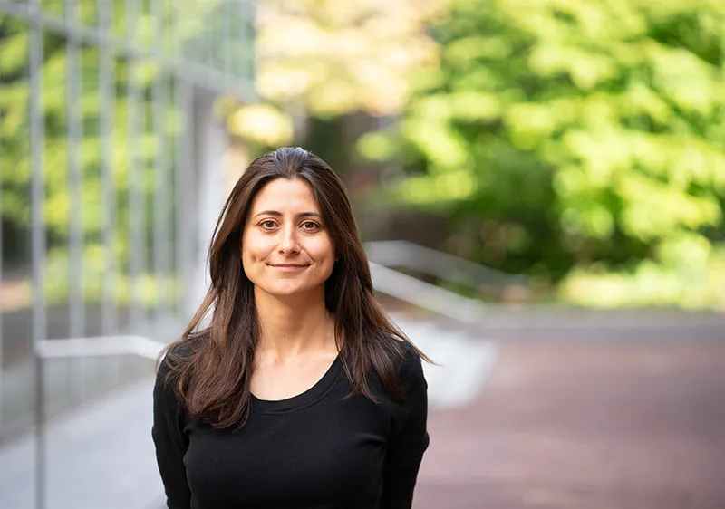 Arwa Mahdawi standing outside in front of building and trees