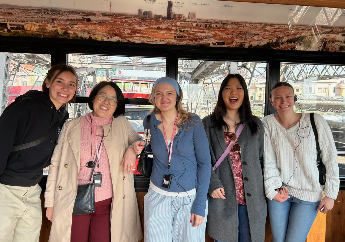 Bridget Barron ‘29, Professor Shen, Katja Wurm ‘28, Eliana Haah ‘26, and Lexi Mireider ‘28 smiling for a photo in one of the cars of the Giant Viennese Ferris Wheel.