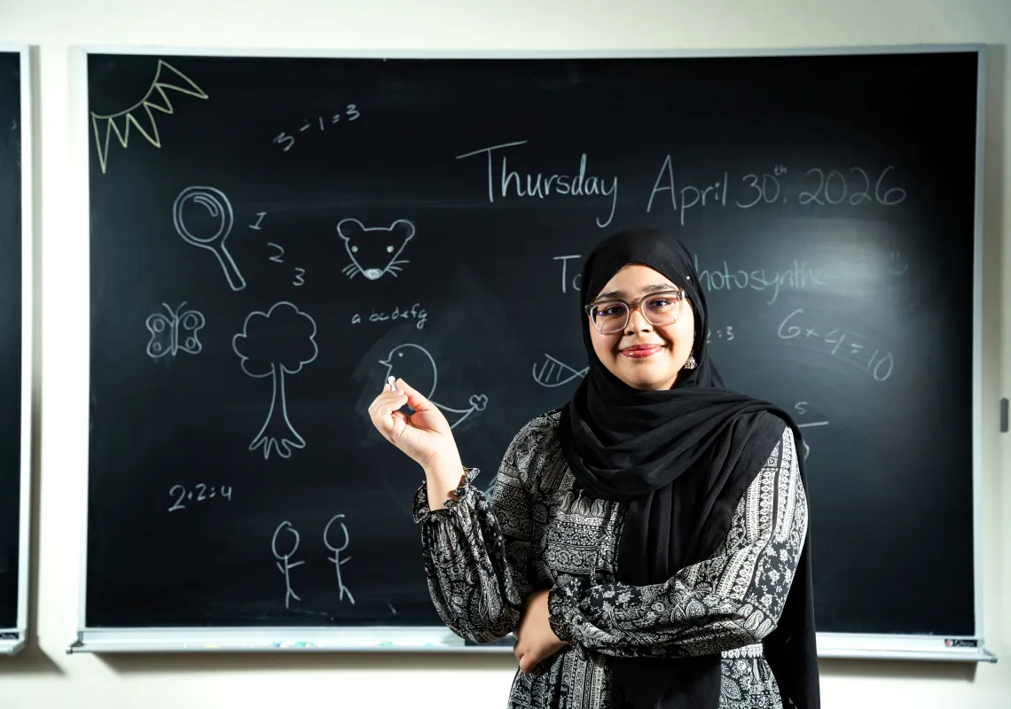 Mahnoor in front of a blackboard