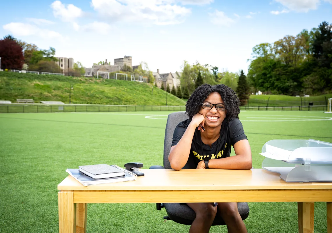 Erica at a desk on the athletic field