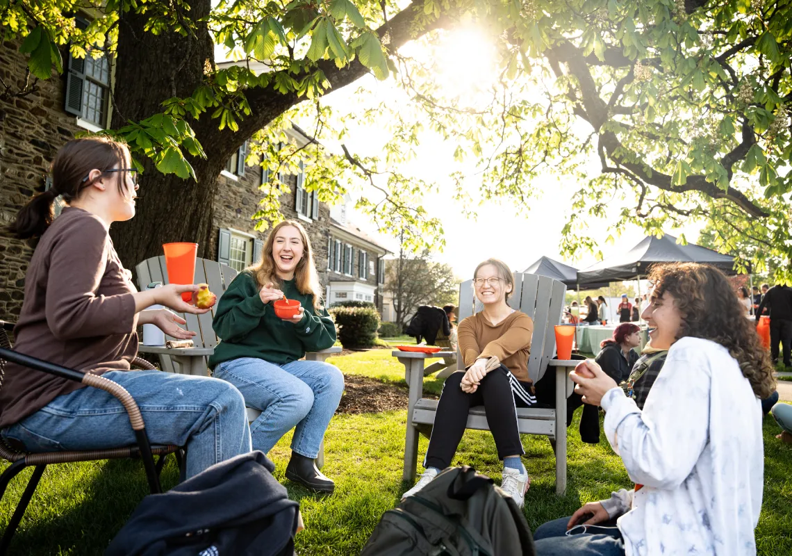Bryn Mawr College students enjoying outdoor campus dining and conversation.