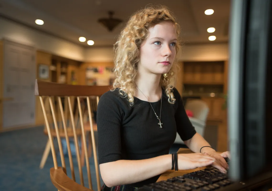 A computer science student sits behind a computer screen