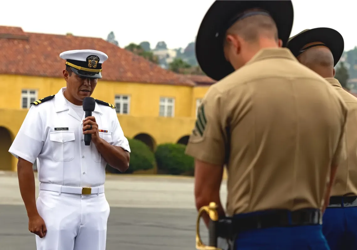 Chaplain Eliseo Morales delivering an invocation during a Marine Corps graduation.