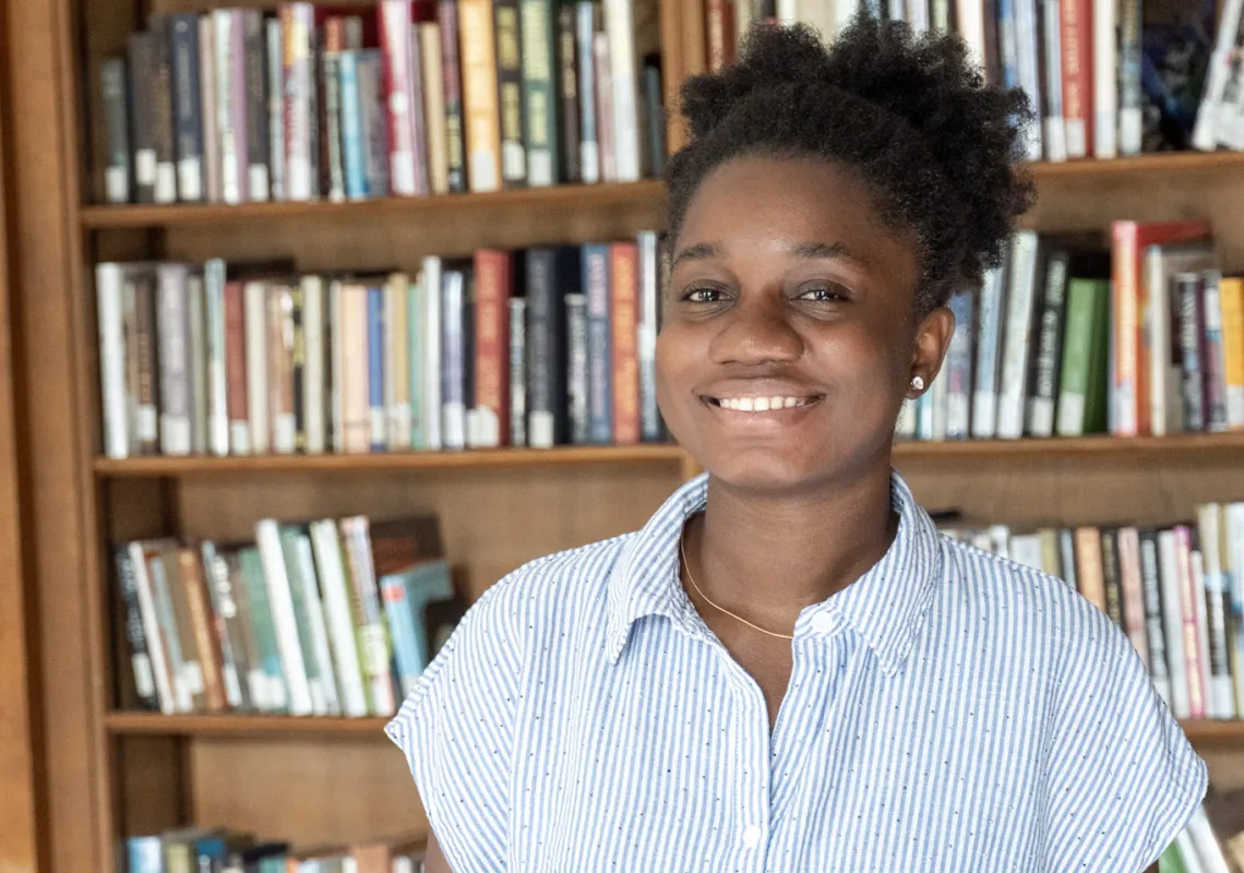 student in front of bookcase