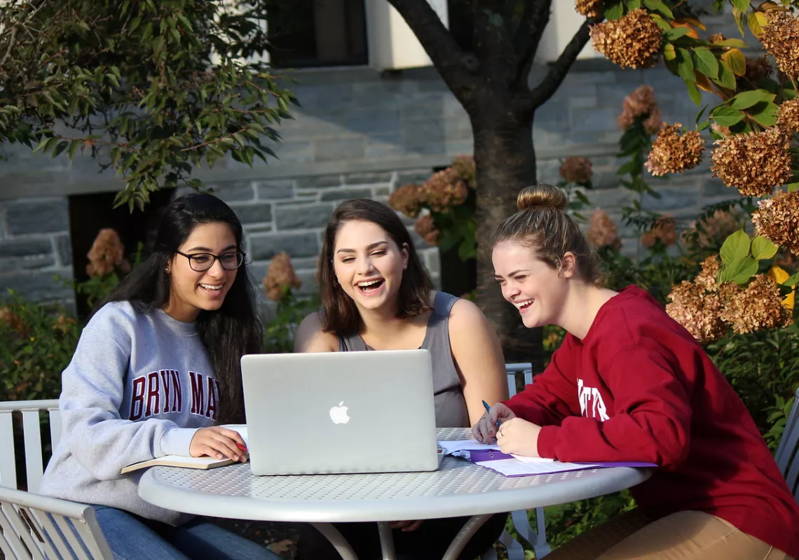 Three students look at computer