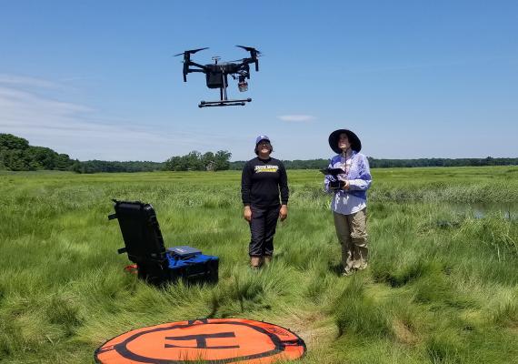Jocelyn Bravo and Angela Kaurin operate a drone in the marshlands of the Plum Island sound.