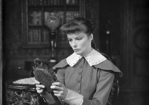 Photograph of Katharine Hepburn holding and looking into a hand mirror