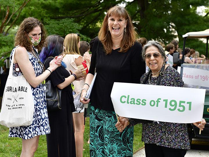 Liela standing with Kim Cassidy at Reunion 2022, holding a "Class of 1951" banner